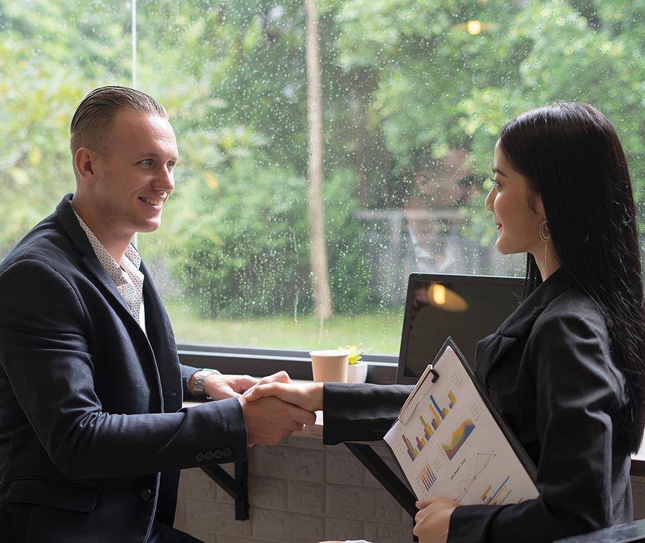 Two professionals in a coffee shop meeting