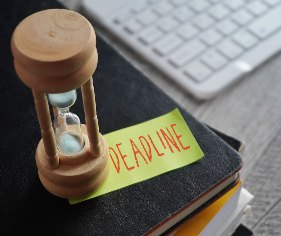 Hourglass on notebook with deadline